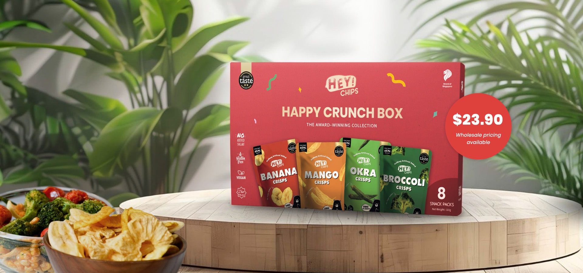 Happy Crunch Box with chips on a wooden table against a green leafy background