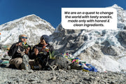 Two people enjoying Hey! Chips while resting during a hike, with the text: 'We are on a quest to change the world with tasty snacks, made only with honest & clean ingredients.'
