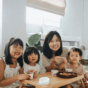 One adult and three children smiling while enjoying Hey! Chips snacks.