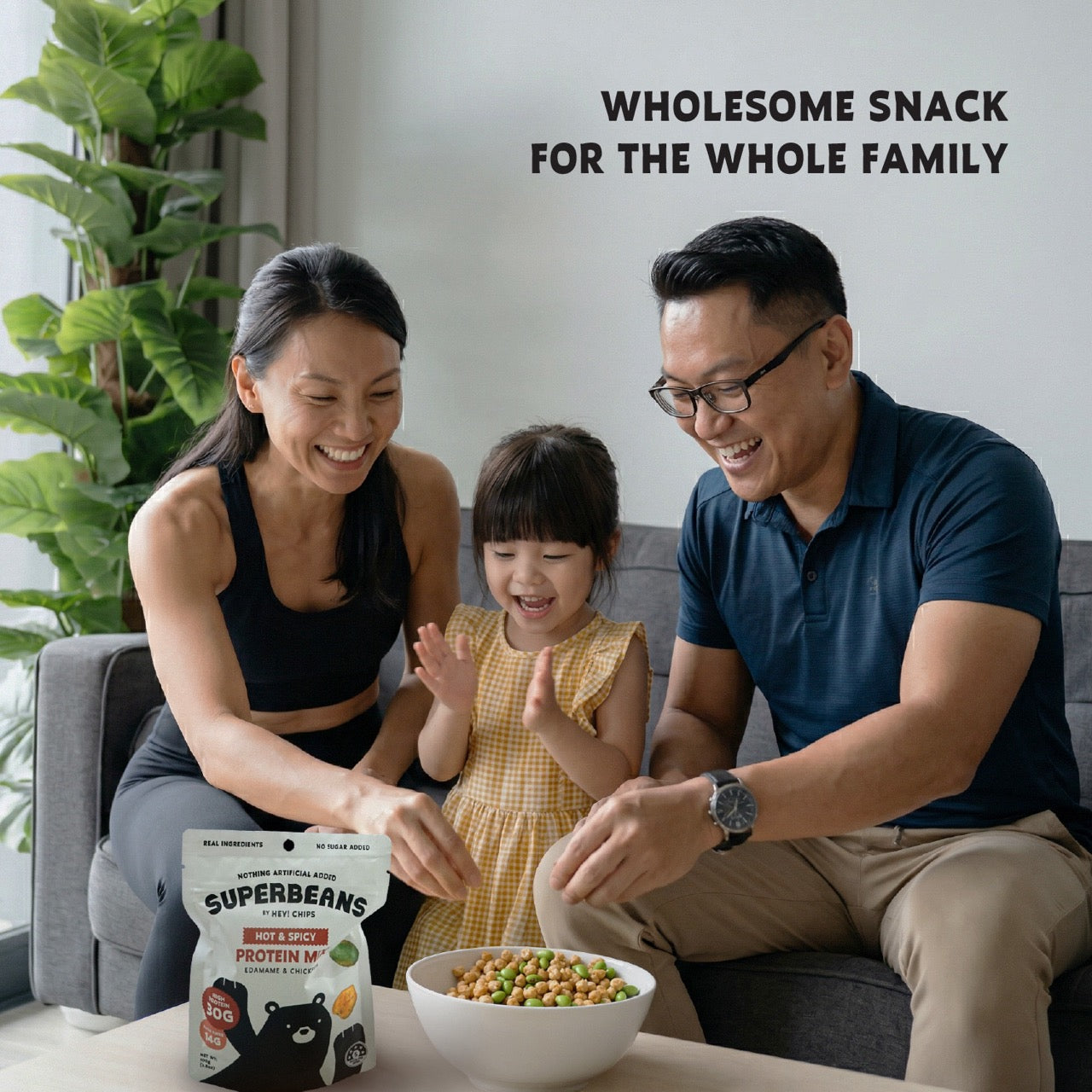 Family sitting on a couch with a bowl of Superbeans snack and a package of Superbeans in the foreground.